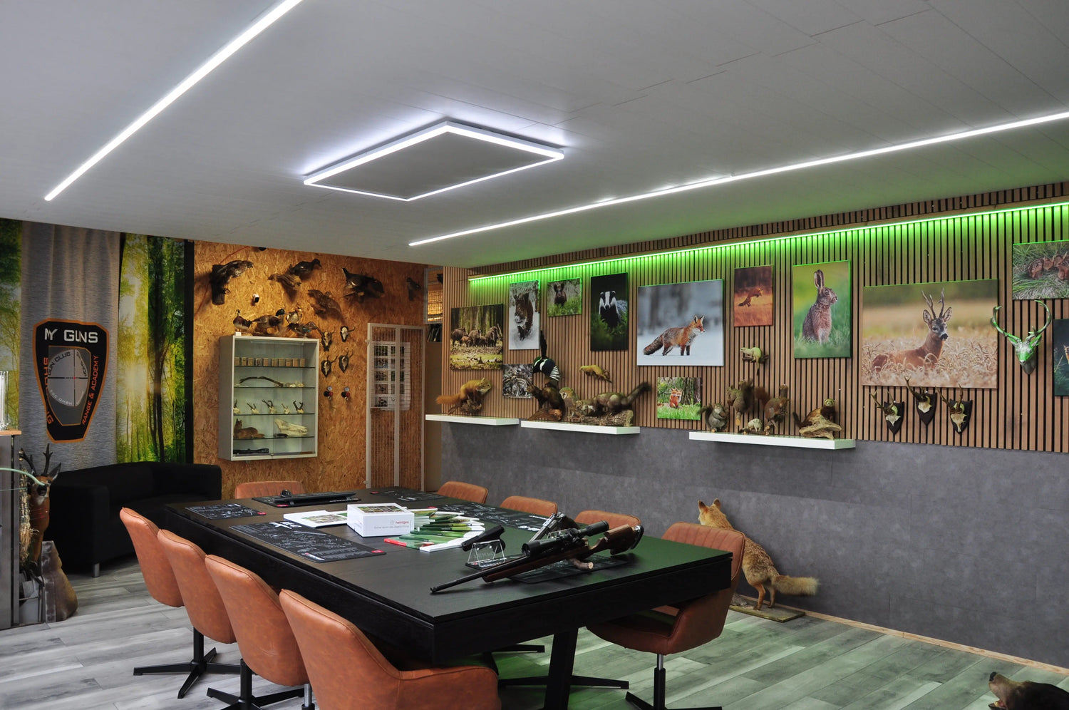 Blick in Schulungsraum mit Tisch und Exponate an der Wand